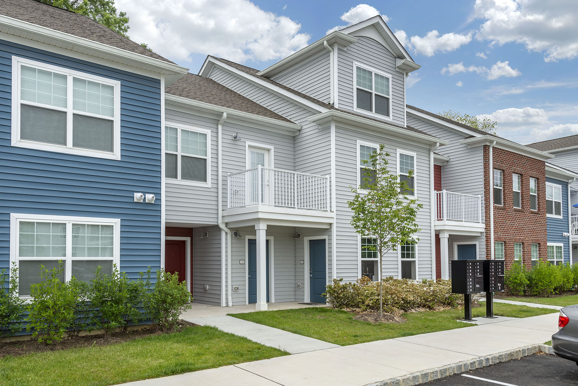 a row of town houses with a sidewalk in front of them